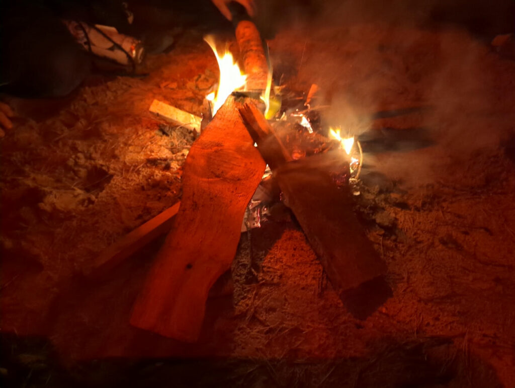 Ein Lagerfeuer auf Sandboden.